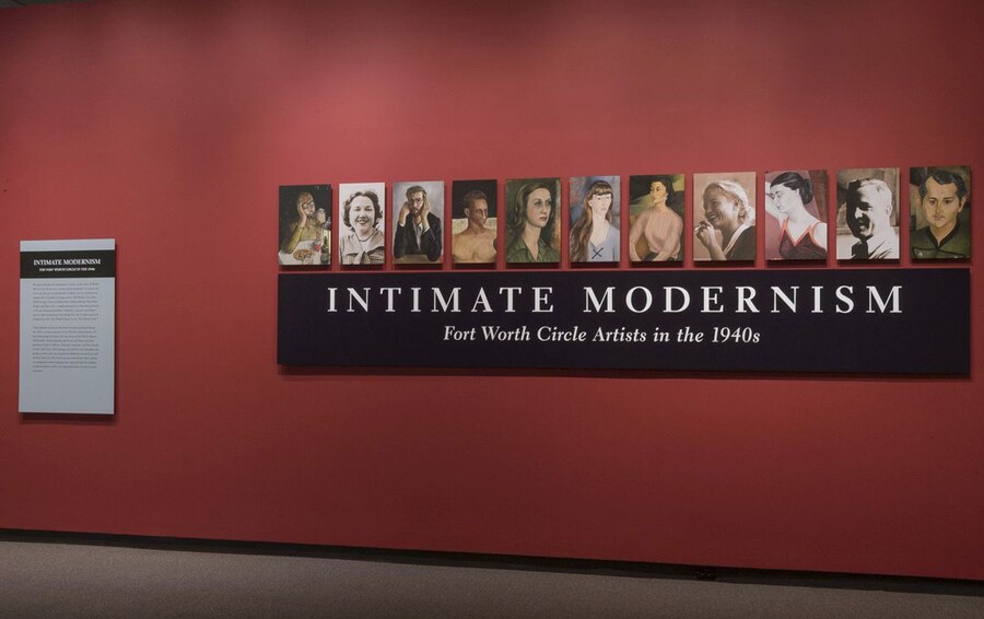 A red title wall with a black panel containing the exhibition title; above it are 11 panels featuring portraits of people.