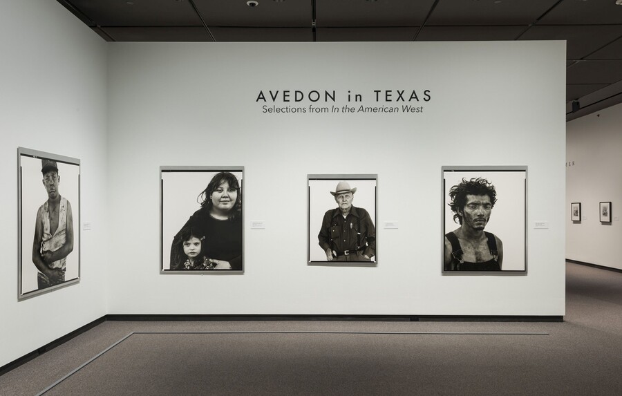 View of exhibition title wall showing three framed black-and-white portraits hanging on a white wall.