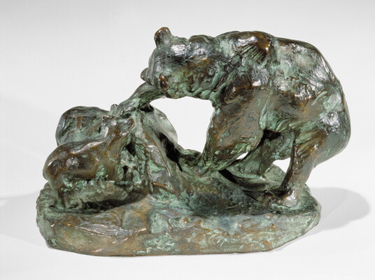 A bronze sculpture of a bear and its cub pawing an upturned rock.