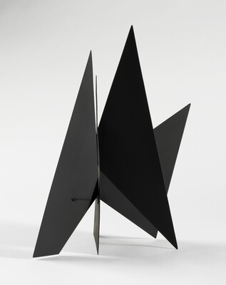 A black abstract tabletop sculpture with lots of triangular points.