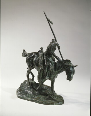 A bronze sculpture of an Indigenous man on horseback holding a spear pointed toward the ground as he studies footprints there.
