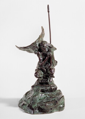 A bronze sculpture of a crouching Indigenous person holding a spear with a open-winged bird perched on their shoulder.