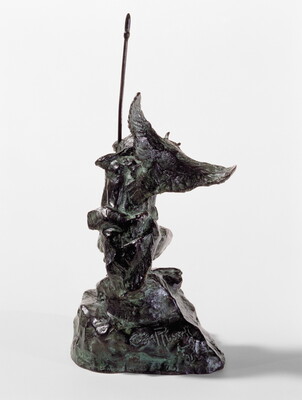 A bronze sculpture of a crouching Indigenous person holding a spear with a open-winged bird perched on their shoulder.
