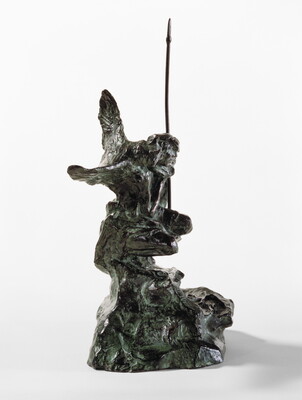 A bronze sculpture of a crouching Indigenous person holding a spear with a open-winged bird perched on their shoulder.