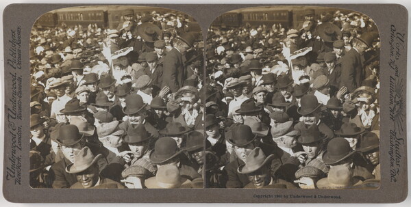Two almost identical side-by-side black-and-white photographs of a large crowd of people, most wearing hats.