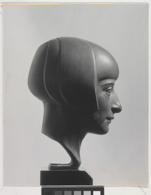 A black-and-white photograph of a bronze bust of a woman in profile with a bobbed haircut.