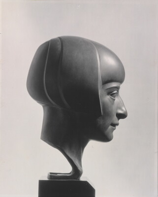 A black-and-white photograph of a bronze bust of a woman in profile with a bobbed haircut.