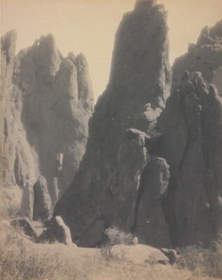 A black-and-white photograph of large hoodoos, or vertical spires of rock.