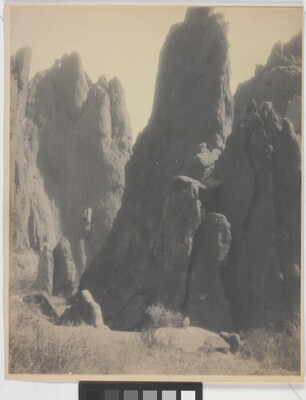 A black-and-white photograph of large hoodoos, or vertical spires of rock.