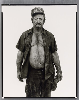 A black-and-white portrait photograph of a middle-aged White man wearing a baseball cap, a dirty, open button-down shirt, and a work glove on one hand.