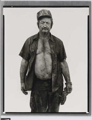 A black-and-white portrait photograph of a middle-aged White man wearing a baseball cap, a dirty, open button-down shirt, and a work glove on one hand.
