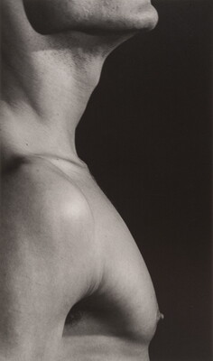 A close-up black-and-white photograph of a White man in profile from chin to just below the shoulders.