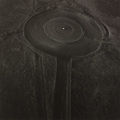 A black-and-white aerial photograph of grassland mown into a series of concentric circles.