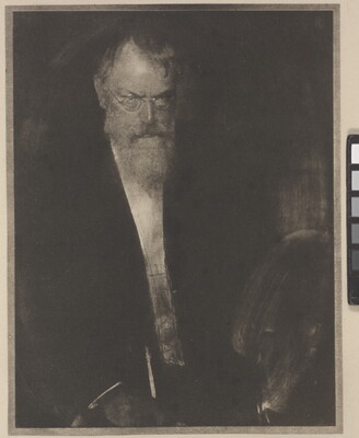 A dark, soft-focus black-and-white portrait photograph of an older White man with glasses looking down and in front of him.