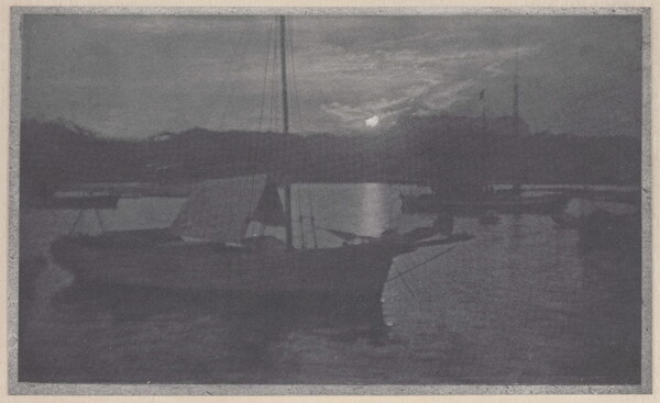 A black-and-white photograph of sailboats with lowered sails in a calm body of water, with a low sun peeking through the clouds near the horizon.