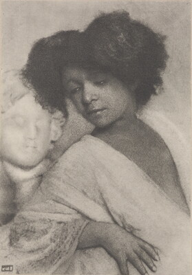 A black-and-white photograph of a dark-skinned woman with short curly hair wearing a white robe leaning back on a white marble sculptural bust.