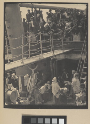 A black-and-white photograph of people outside on two decks of a crowded ship.
