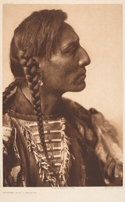 A sepia-toned portrait photograph of an Indigenous man in profile, hair in braids, wearing a beaded tunic with decorative fringe.