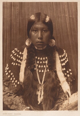 A sepia-toned portrait photograph of an Indigenous girl from the waist up dressed in traditional clothing.