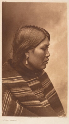 A sepia-toned portrait photograph of an Indigenous woman in profile, wearing a striped blanket or shawl over her shoulders.