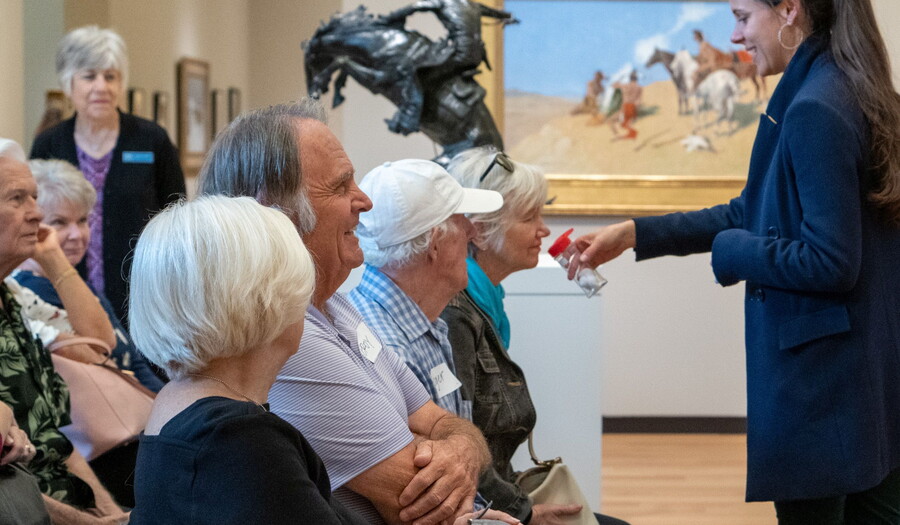 A group smells something held by a staff member in the Carter galleries