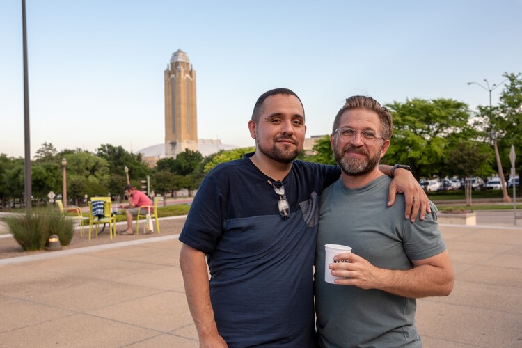 Two men stand on the Carter porch with a drink