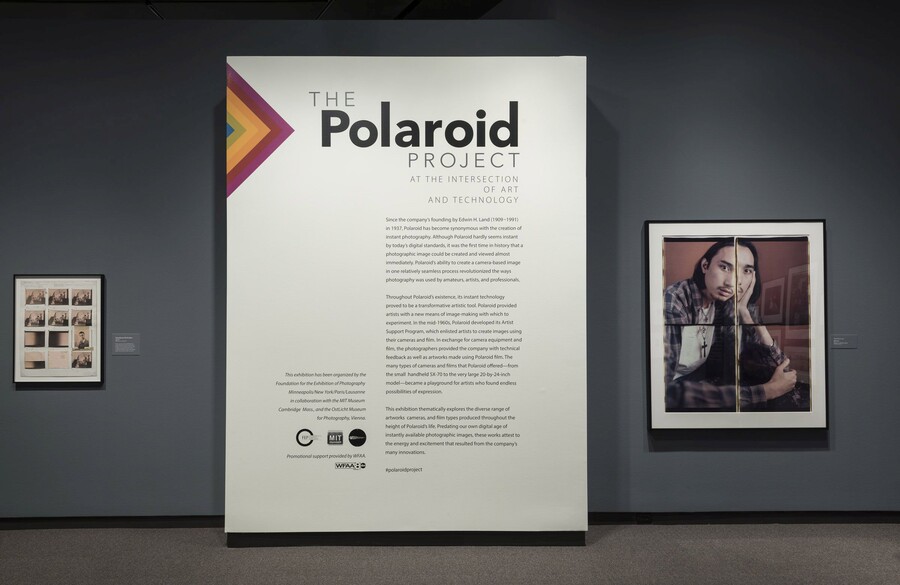 Exhibition title wall featuring introductory text on a white panel. To the right is a framed photo collage portrait of a man; to the left is a framed contact sheet.