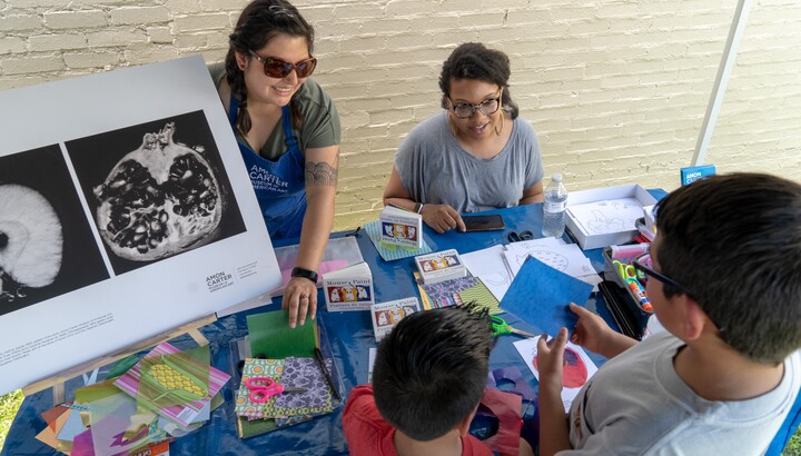 People looking at artwork on a table