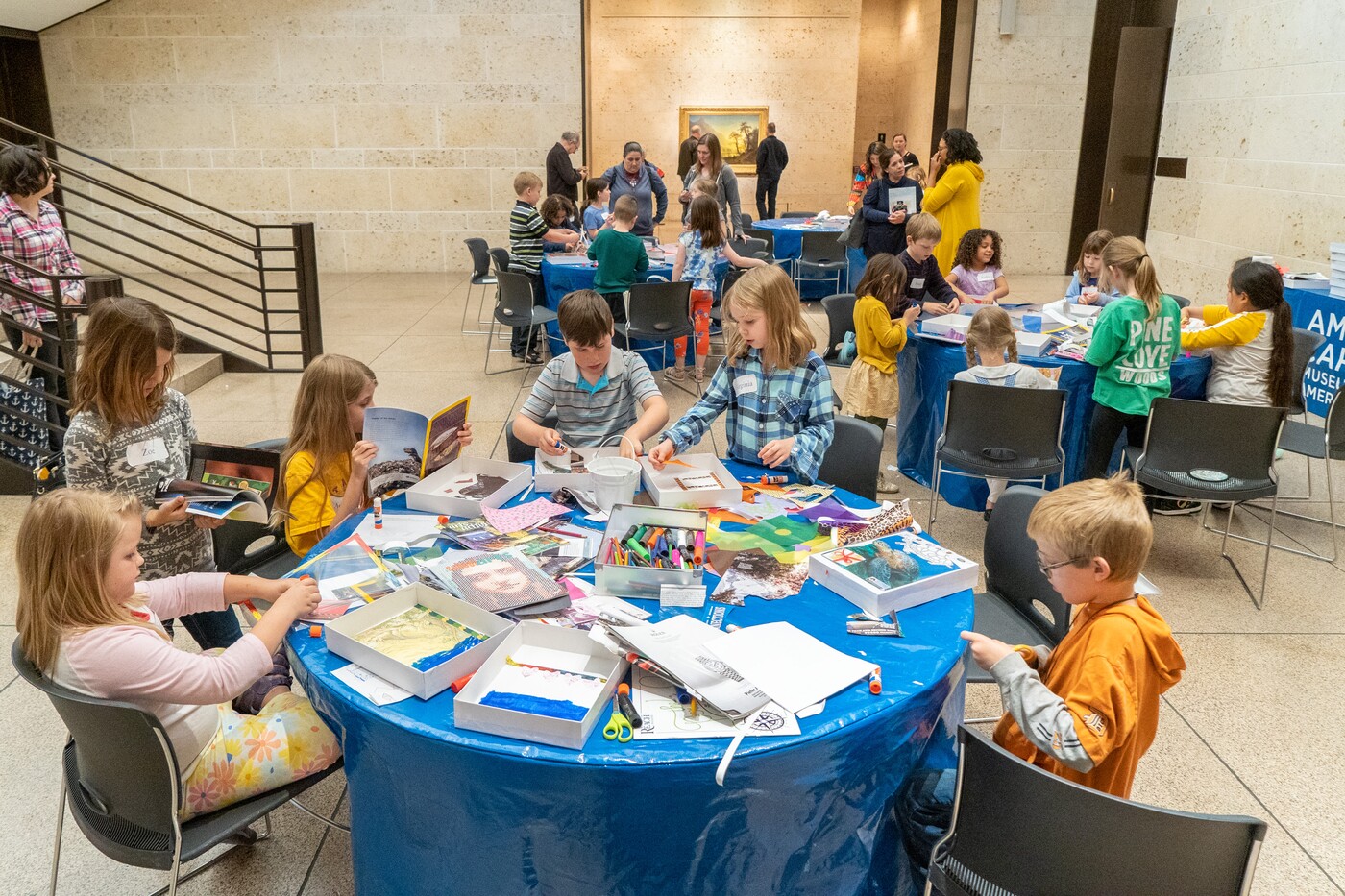 Children work at tables in the Carter atrium
