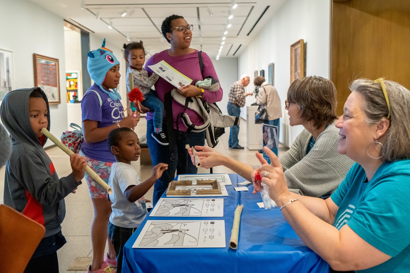 Children and adults in gallery around table with interactive activities