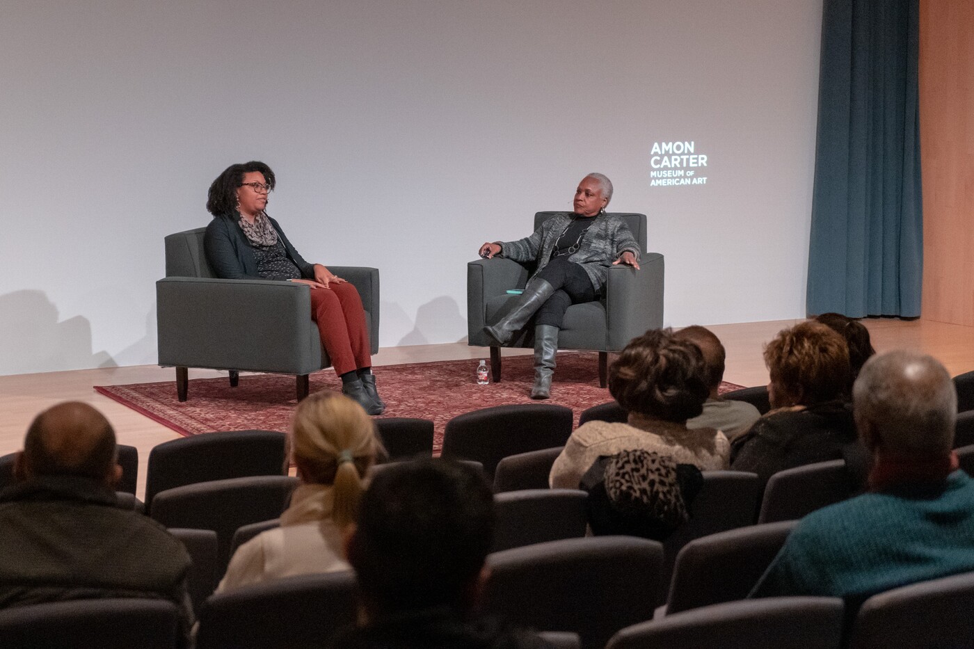 two women talking on a stage