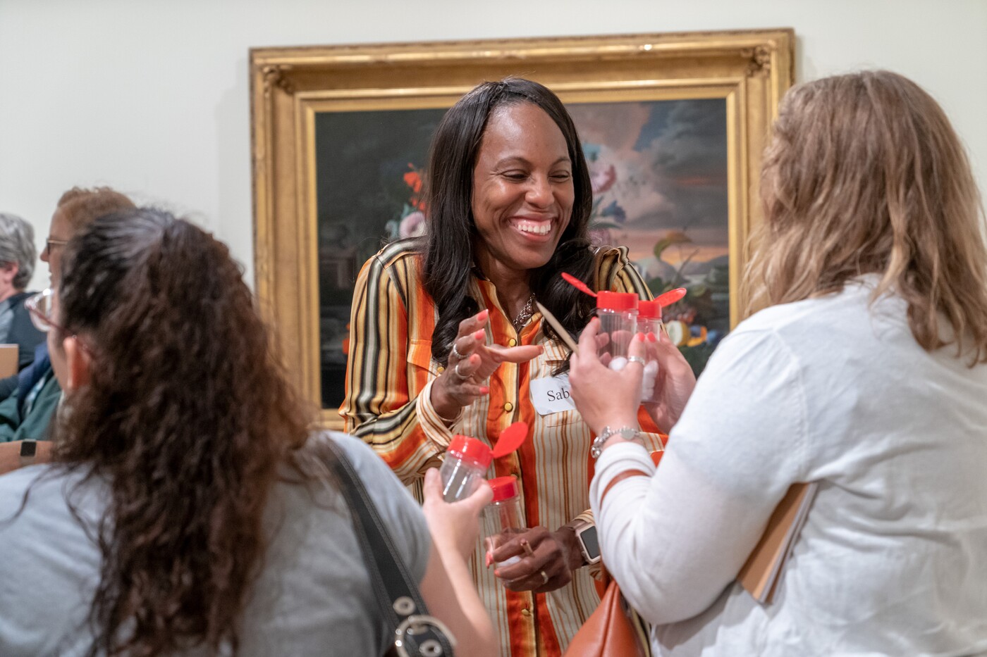 Women standing in gallery smell from clear open bottles