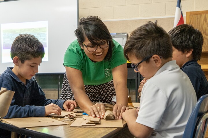 Teacher with three students working on an art project