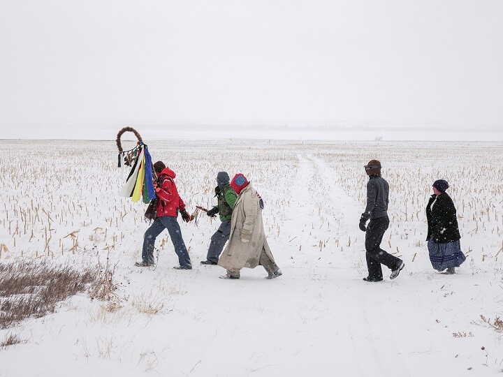 five figures walking through snow