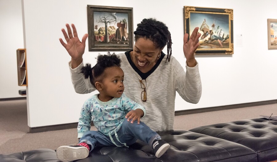 mom and toddler on a bench in an art gallery