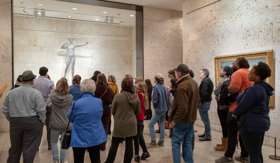 A crowd stands around looking at the sculpture Diana by Augustus Saint-Gaudens
