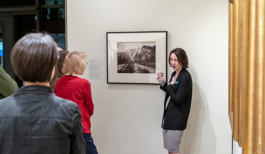 Amon Carter Curator leading a tour in front of a photograph