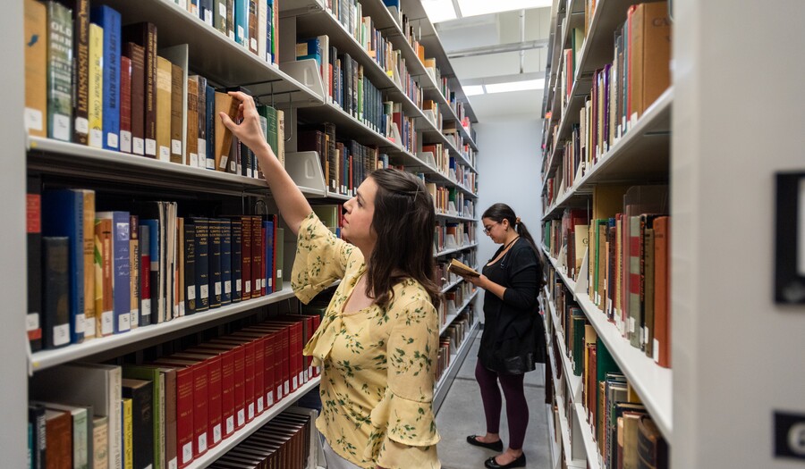Two women in library stacks