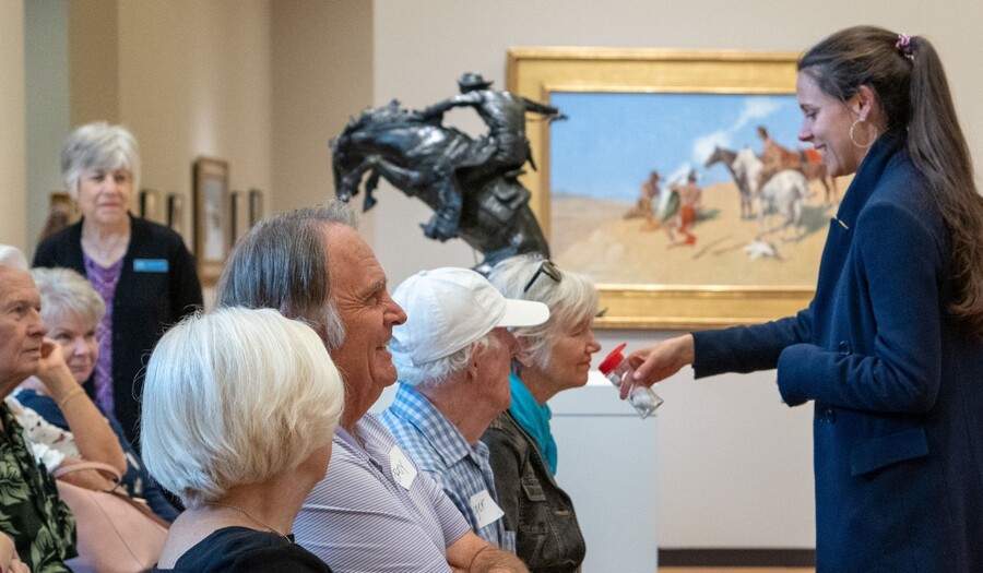 A group smells something held by a staff member in the Carter galleries