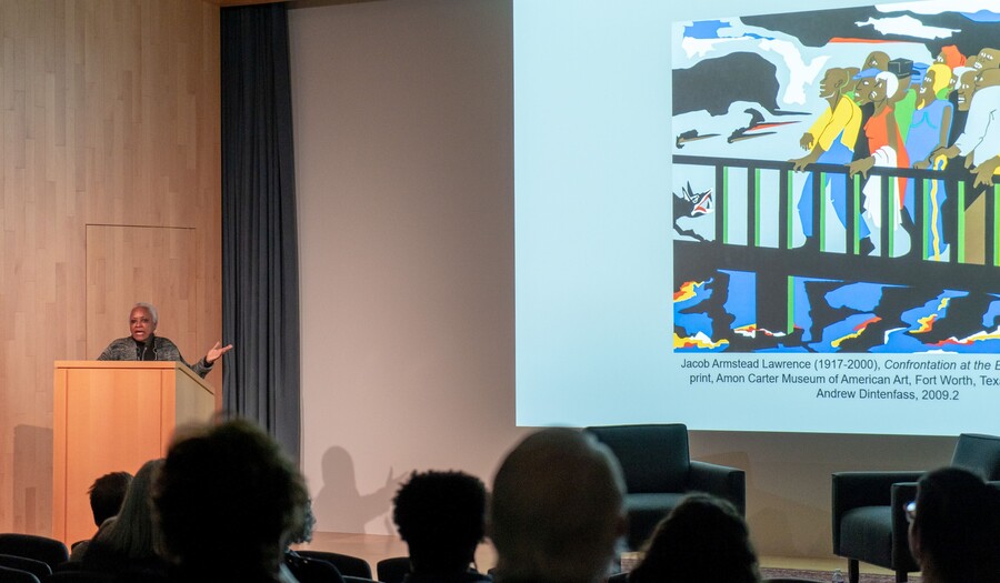 woman at podium discussing art on screen