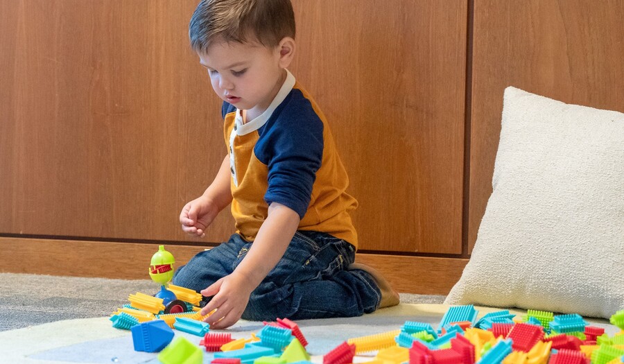 little boy playing with connecting blocks
