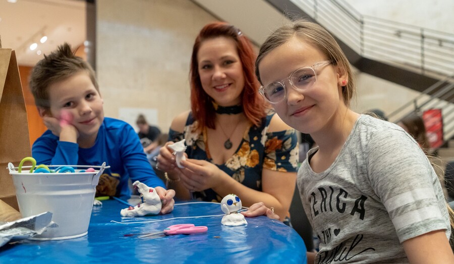 a boy and a girl making art with their mom