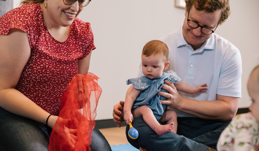 teacher with baby and dad playing with a scarf