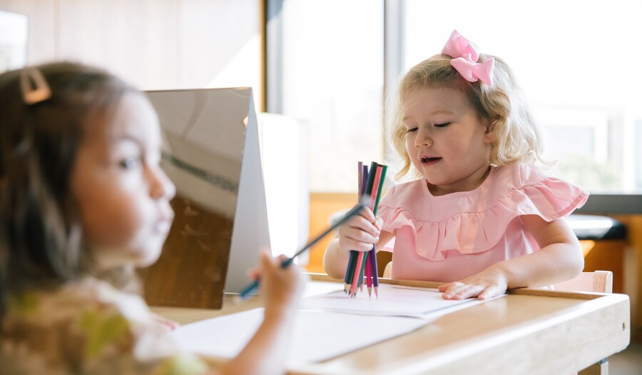 two toddlers coloring with mirrors