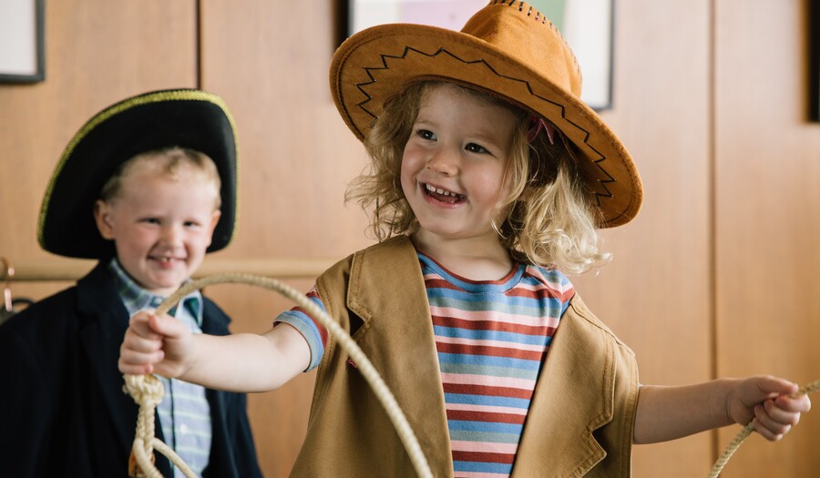 little boy wearing colonial hat and a little girl dressed as a cowgirl