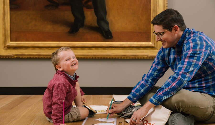 father and son in front of a painting drawing