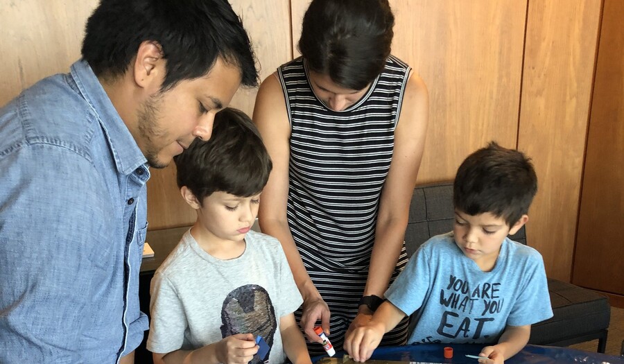 dad, mom, and two boys making art