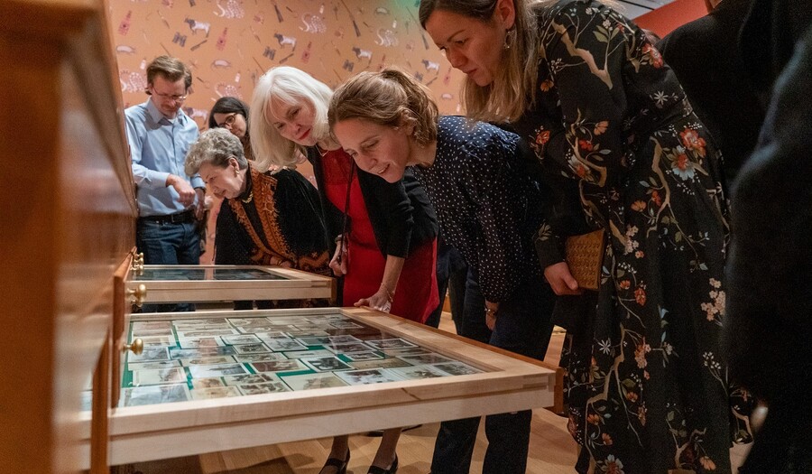 women looking at art in a cabinet